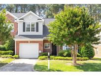 Charming brick home with a well-manicured lawn, attached garage, and lush landscaping at 2089 White Pond Ct, Apex, NC 27523