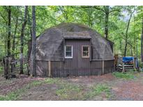 Unique geodesic dome home featuring a shingled roof nestled within a wooded landscape at 3312 Hawk Ridge Rd, Chapel Hill, NC 27516