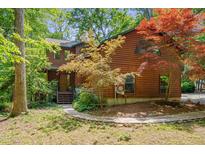 Charming multi-story home with natural wood siding, landscaped yard, and mature trees at 3622 Moonlight Dr, Chapel Hill, NC 27516