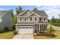 Charming two-story home featuring a well-manicured front yard and a two-car garage at 3700 Horton Hill Dr, New Hill, NC 27562