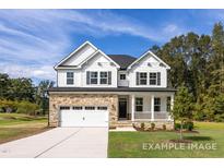 Charming two-story home featuring a stone-accented facade, white siding, and a welcoming front porch at 416 Longleaf Glen Ln, Zebulon, NC 27597