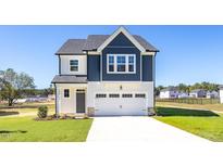 Charming two-story home featuring a crisp white garage door and a combination of white and navy blue siding at 420 Longleaf Glen Ln, Zebulon, NC 27597