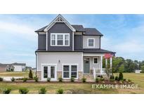 Charming two-story home with a mix of gray and white siding, a cozy front porch, and a well-manicured lawn at 420 Longleaf Glen Ln, Zebulon, NC 27597