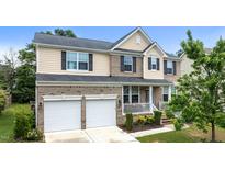 Charming two-story home features a two-car garage and a cozy front porch, complemented by manicured landscaping at 513 Heswall Ct, Rolesville, NC 27571
