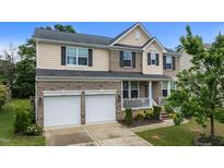 Charming two-story home with a two-car garage, manicured lawn, and inviting front porch at 513 Heswall Ct, Rolesville, NC 27571