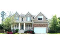 Charming two-story home featuring blue shutters, a covered porch, and an attached two-car garage at 704 Valleywater St, Fuquay Varina, NC 27526