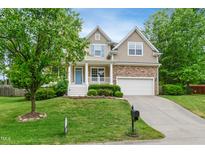 Charming home with a stone-accented facade, manicured lawn, and a welcoming blue front door at 704 Valleywater St, Fuquay Varina, NC 27526