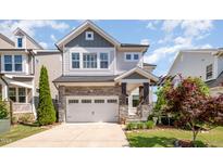 Charming two-story home with a stone-accented facade, attached garage, and manicured landscaping at 79 Tarwick Ave, Chapel Hill, NC 27516