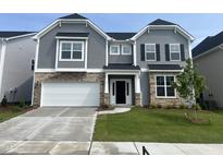 Charming two-story home features stone accents, gray siding, manicured lawn, and a two-car garage at 95 Black Walnut Dr # 191, Garner, NC 27529