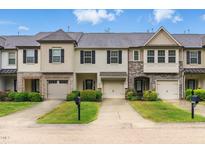 Charming townhome with stone accents, well-maintained landscaping, and attached garages at 9805 Precious Stone Dr, Wake Forest, NC 27587