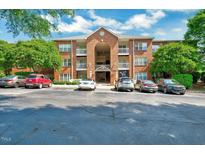 Brick apartment building with multiple balconies and parking spaces in front at 107 Sturbridge Dr, Clayton, NC 27520