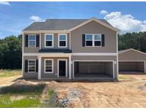 Charming two-story home featuring neutral siding, dark shutters, and an attached two-car garage, complemented by an extra detached garage at 109 Sagamore Avenue, Angier, NC 27501