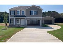 Two-story home featuring a covered carport and a detached garage on a large landscaped lawn at 109 Sagamore Avenue, Angier, NC 27501
