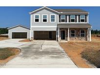 Two-story home with an attached and detached garage, and a concrete driveway on a sunny day at 112 Sagamore Avenue, Angier, NC 27501