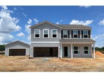 New two-story home with attached garage and detached garage on a large lot ready for landscaping at 112 Sagamore Avenue, Angier, NC 27501