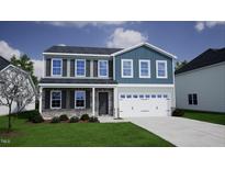 Charming two-story home featuring stone accents, a two-car garage, and a well-manicured lawn at 112 Sagamore Avenue, Angier, NC 27501