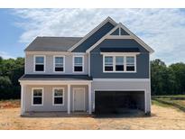Charming two-story home with a two-car garage and light-grey and dark-blue siding at 129 Sagamore Ave., Angier, NC 27501