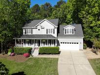 Charming two-story home with a covered front porch, well-manicured lawn, and attached two-car garage at 141 Clay Ridge Way, Holly Springs, NC 27540