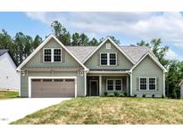 Charming green two-story home featuring a two-car garage and well-manicured lawn at 1412 Sagamore Dr, Louisburg, NC 27549