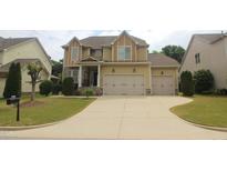 Two-story home featuring a two-car garage, stone accents and well-manicured landscaping at 1549 Lily Creek Dr, Cary, NC 27518