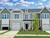 Charming townhome exterior showcasing a well-manicured lawn and attached garages at 162 Ripple Way # 322, Clayton, NC 27520
