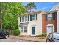 Charming townhome featuring a classic yellow facade with green shutters and a well-manicured front yard at 216 Climbing Ivy Ct, Cary, NC 27511