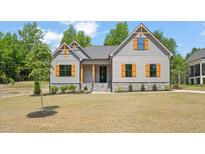 Charming home featuring board and batten siding, natural wood shutters, and a well-manicured lawn at 260 Pilot Ridge Rd, Zebulon, NC 27597