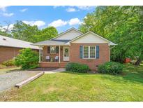 Charming brick home with a cozy front porch and a well-manicured lawn at 34 Johnston St, Pittsboro, NC 27312