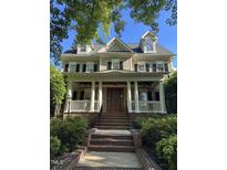 Charming two-story home featuring a welcoming front porch with classic columns and a well-manicured front yard at 3821 Falls River Ave, Raleigh, NC 27614