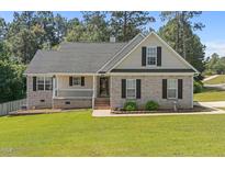 Charming single Gathering home featuring a lush green lawn, and a welcoming porch perfect for relaxing at 48 Arlington Dr, Cameron, NC 28326