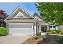Charming home showcasing a manicured lawn, colorful flowerbeds, and an attached two-car garage at 524 Clarenbridge Dr, Cary, NC 27519