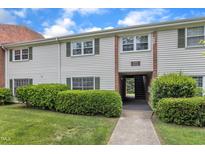 Charming townhouse featuring well-maintained landscaping, vinyl siding and green shutters at 5602 Falls Of Neuse Rd # E, Raleigh, NC 27609