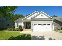 Charming single-Gathering home featuring a two-car garage and well-maintained landscaping for great curb appeal at 65 Wood Green Dr, Wendell, NC 27591
