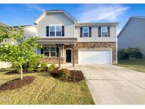 Charming two-story home with a landscaped front yard and a two-car garage at 664 Lavenham Ln, Fuquay Varina, NC 27526