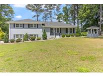 Charming light grey two-story home with a well manicured yard and mature trees at 103 Rex Pl, Louisburg, NC 27549