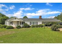 Charming single-story home featuring a well-maintained lawn and convenient carport for covered parking at 1169 Clayhole Rd, Dunn, NC 28334