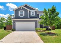 Charming two-story home featuring a two-car garage, a well-manicured lawn, and classic architectural details at 45 Iris Dr, Youngsville, NC 27596