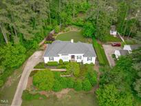 Stunning aerial view of a beautifully landscaped home with a gray roof surrounded by lush greenery at 4830 North Hills, Raleigh, NC 27612