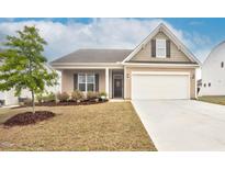 Charming single Gathering home with a two-car garage, manicured lawn and beautiful landscaping at 74 Hidden Grove Ct, Garner, NC 27529