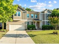 Charming two-story home featuring a well-manicured lawn, attached two-car garage, and traditional architectural details at 109 Highland Mist Cir, Apex, NC 27539