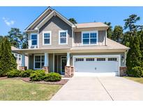 Charming two-story home boasts a manicured lawn, stone accents, and a convenient two-car garage at 112 Victorian Oaks Dr, Durham, NC 27713