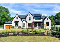 Stunning exterior of a two-story home with stone accents, black trim, and professional landscaping at 1209 Briar Patch Ln, Raleigh, NC 27615