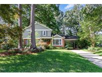 Charming two-story home with lush landscaping, brick accents and a convenient carport at 1324 Swallow Dr, Raleigh, NC 27606