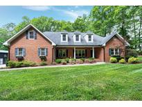 Charming brick home features a manicured lawn, flower boxes, and a welcoming front porch for relaxing outdoors at 168 E Deer, Apex, NC 27523