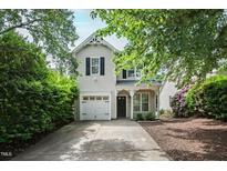 Charming two-story home with a well-manicured lawn and attached garage, framed by mature trees at 1910 Falls Landing Dr, Raleigh, NC 27614