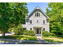 Charming two-story home featuring light gray siding, well-maintained landscaping, and a welcoming front porch at 2111 Woodland Ave, Raleigh, NC 27608