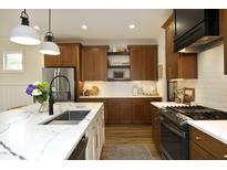 Modern kitchen boasts marble countertops, stainless steel appliances, and wood cabinets at 2200 Mays Crossroads Rd, Louisburg, NC 27549