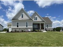 Charming home with stone accents, well-manicured lawn, and inviting front porch at 25 Deer Tail Ln # 52, Fuquay Varina, NC 27526