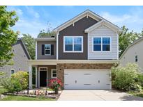 Charming two-story home featuring a stone-accented facade, two-car garage, and a beautifully landscaped front yard at 2513 Magnolia Tree Ln, Durham, NC 27703