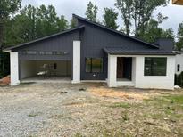 Modern home with white painted brick and black siding, offering a sleek and contemporary design at 269 Deer Tail Ln # 44, Fuquay Varina, NC 27526